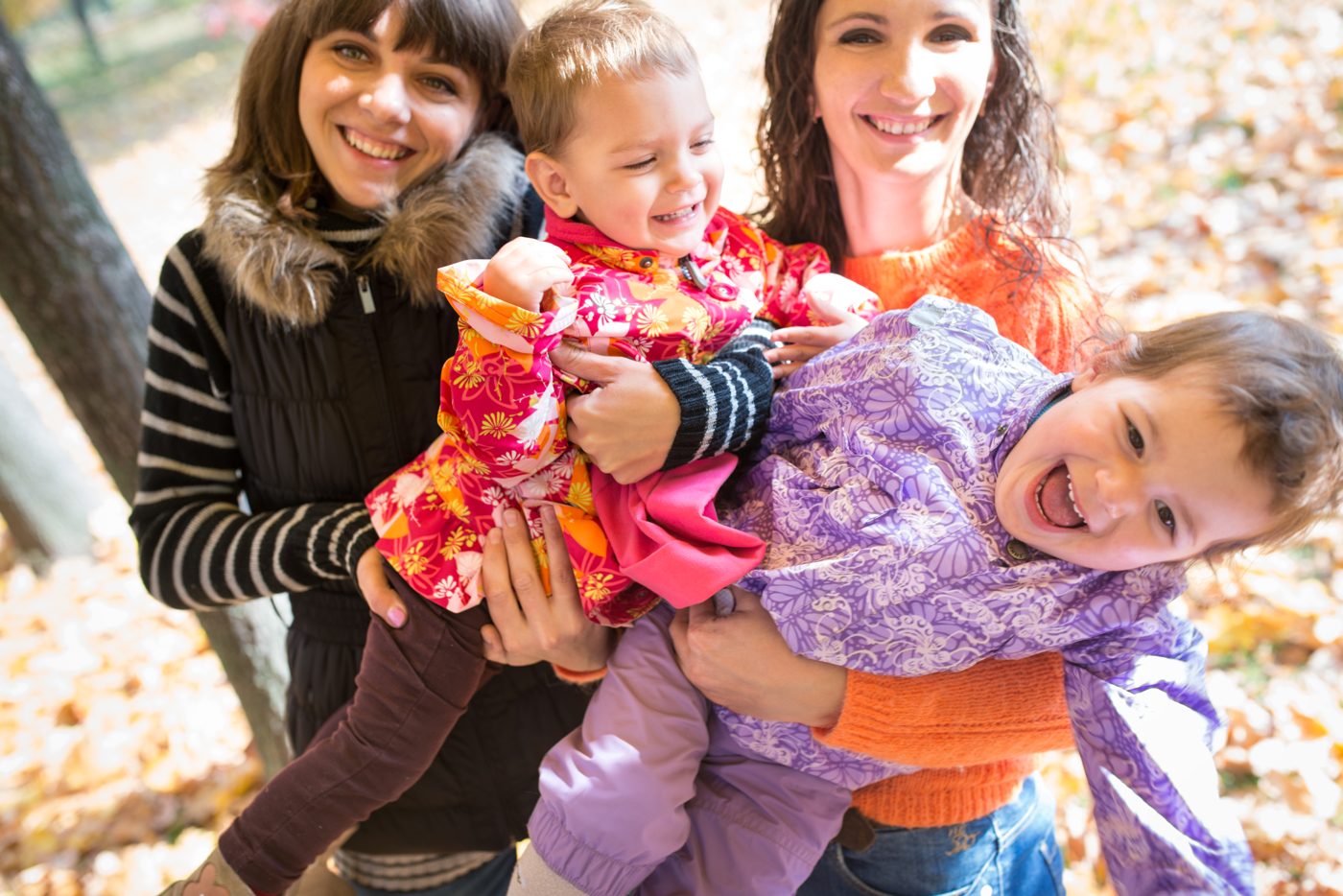 Smiling women and children together outdoors